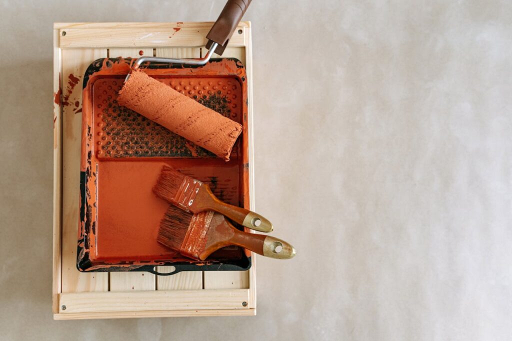 An overhead shot of paintbrushes and a roller in a tray, perfect for home renovation projects.
